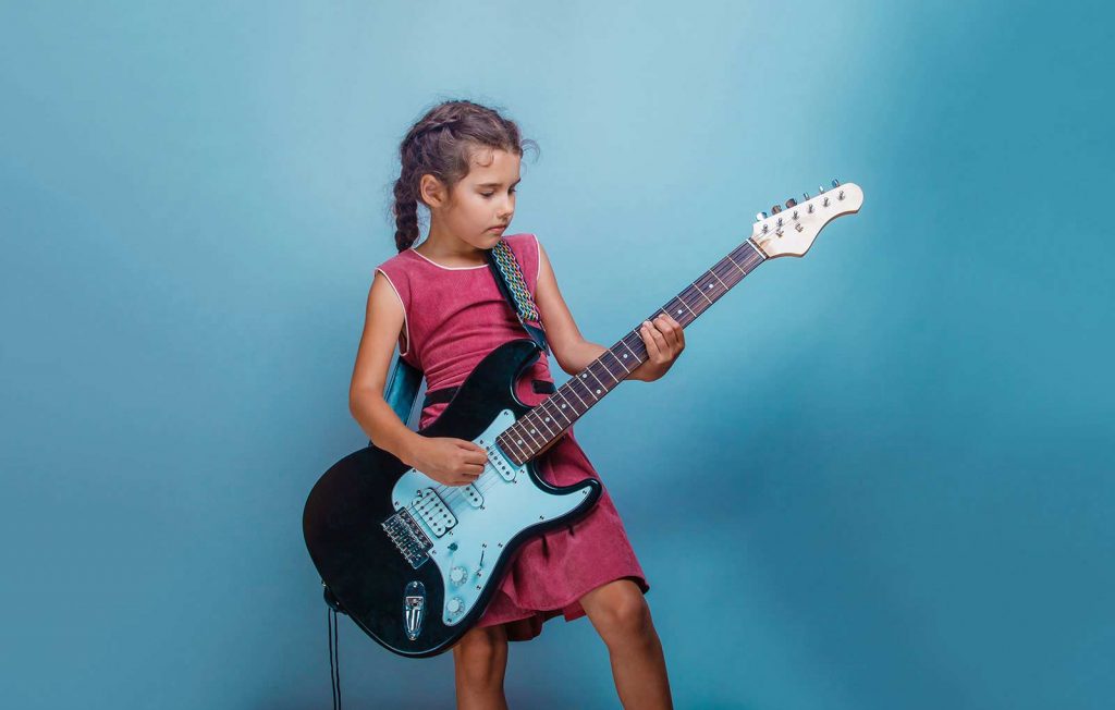 Niña tocando guitarra eléctrica