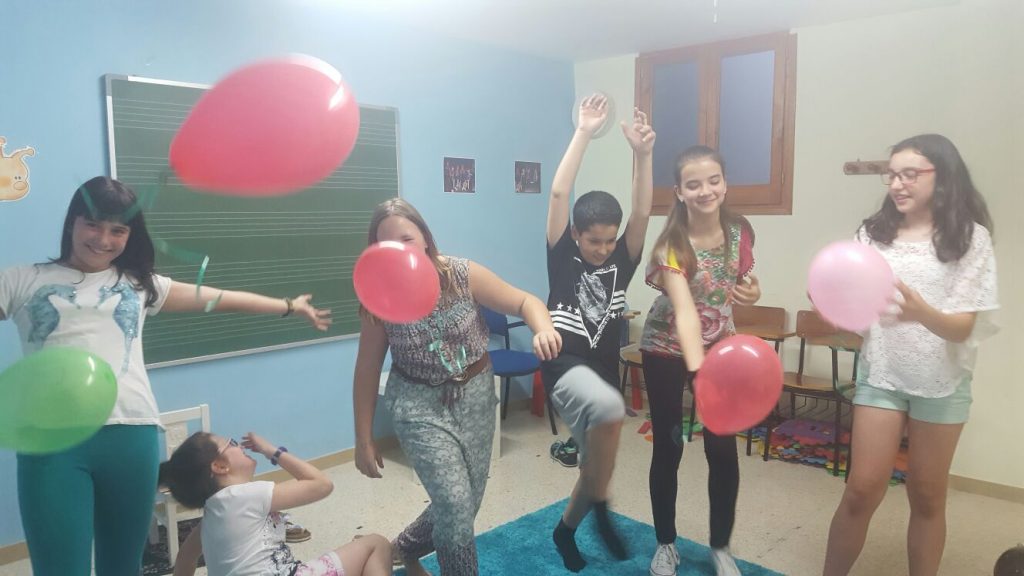 Niños con globos jugando en aula de clases