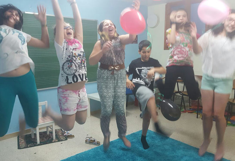 Niños con globos jugando en aula de clases