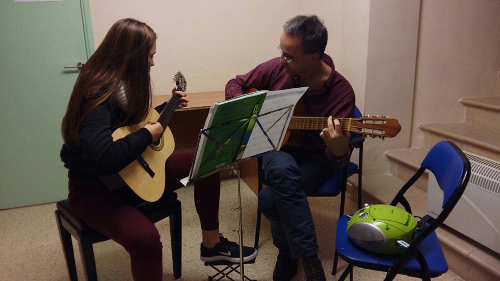 Alumna y profesor en Clases de Guitarra