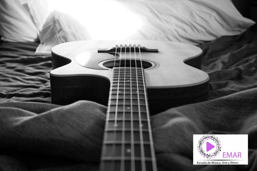 foto de una guitarra en posición horizontal con logo de escuela de música Emar