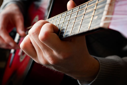 Primer plano de manos tocando la guitarra