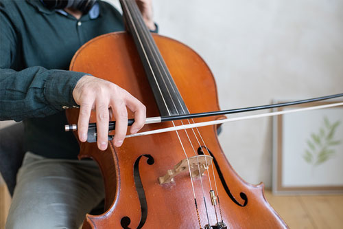 Primer plano de manos de hombre tocando el violonchelo