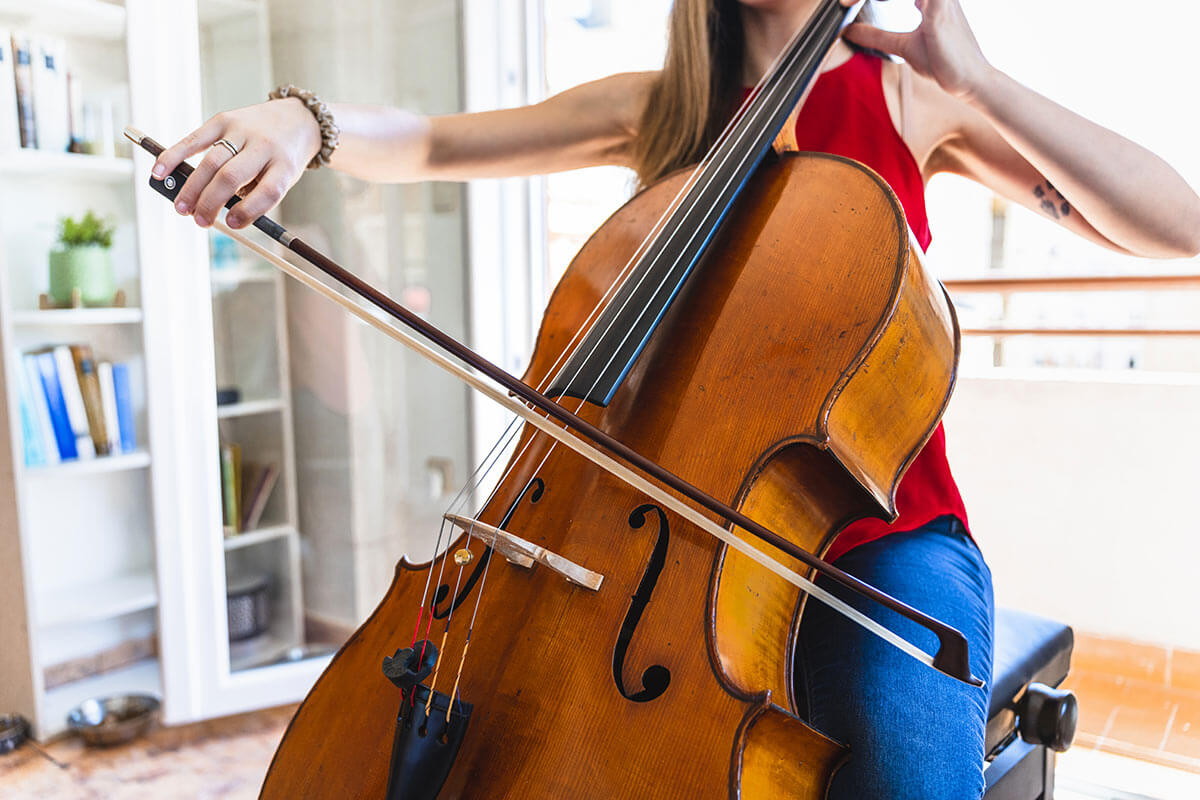 mujer joven tocando el violonchelo en primer plano en habitación