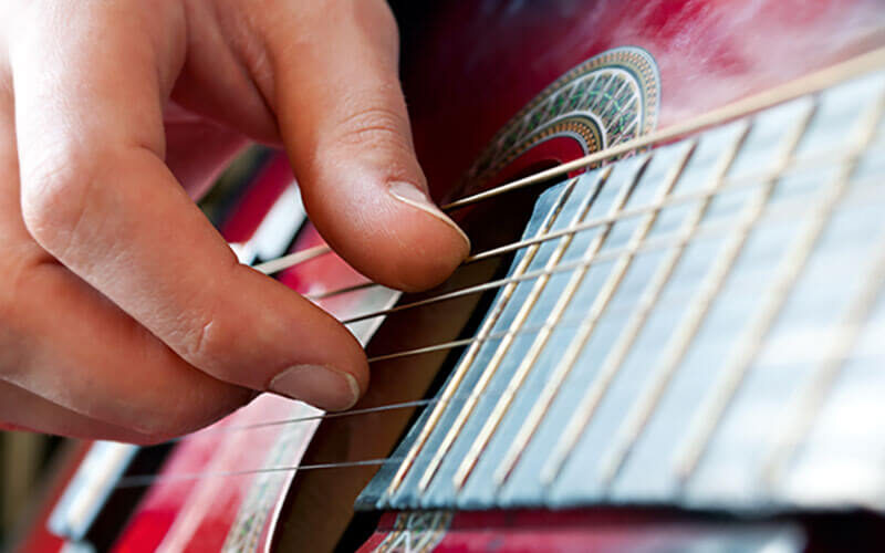 Primer plano de mano tocando la guitarra