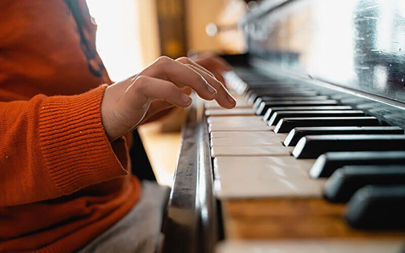 Manos de niño tocando el piano