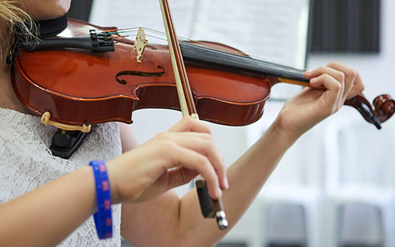 Manos de mujer joven tocando el violín